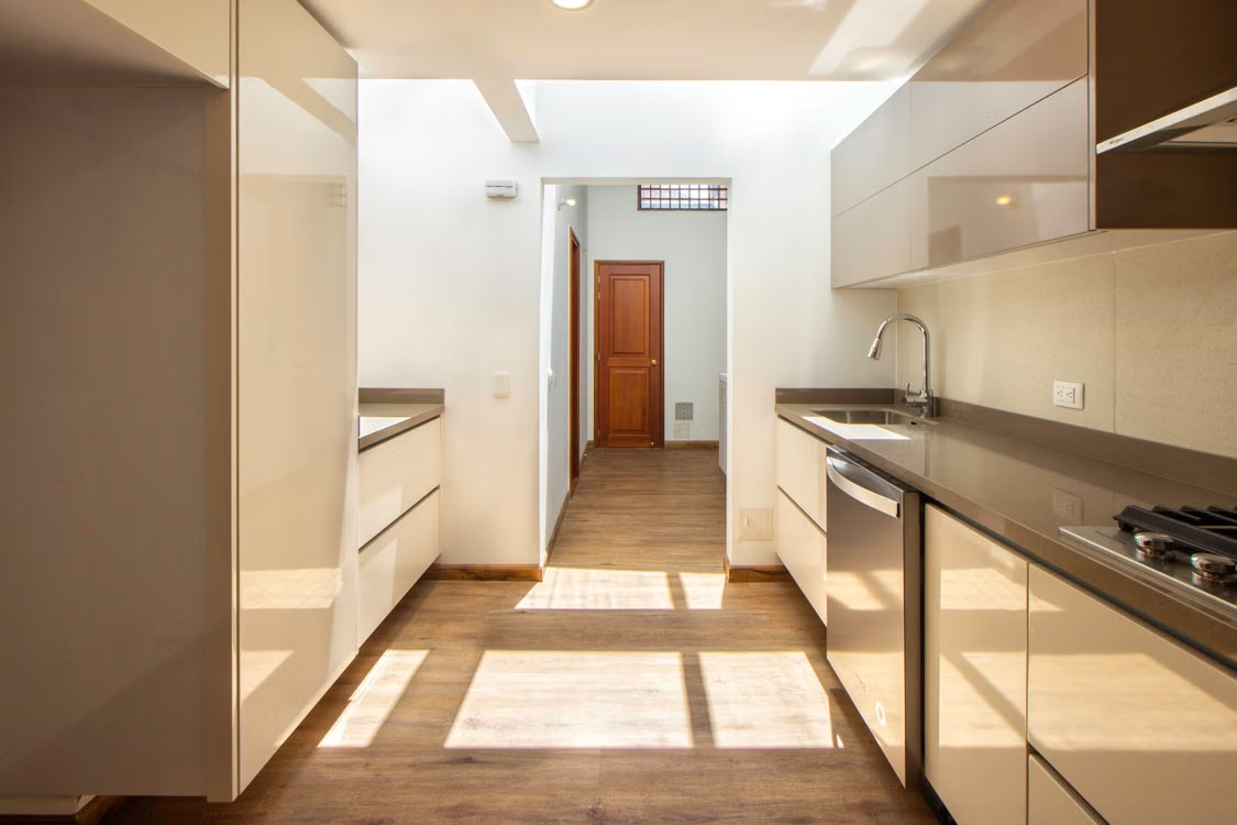 Cocina office reformada con muebles lacados y suelo de madera